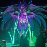 giant illuminated metal bird at outdoor art festival at night
