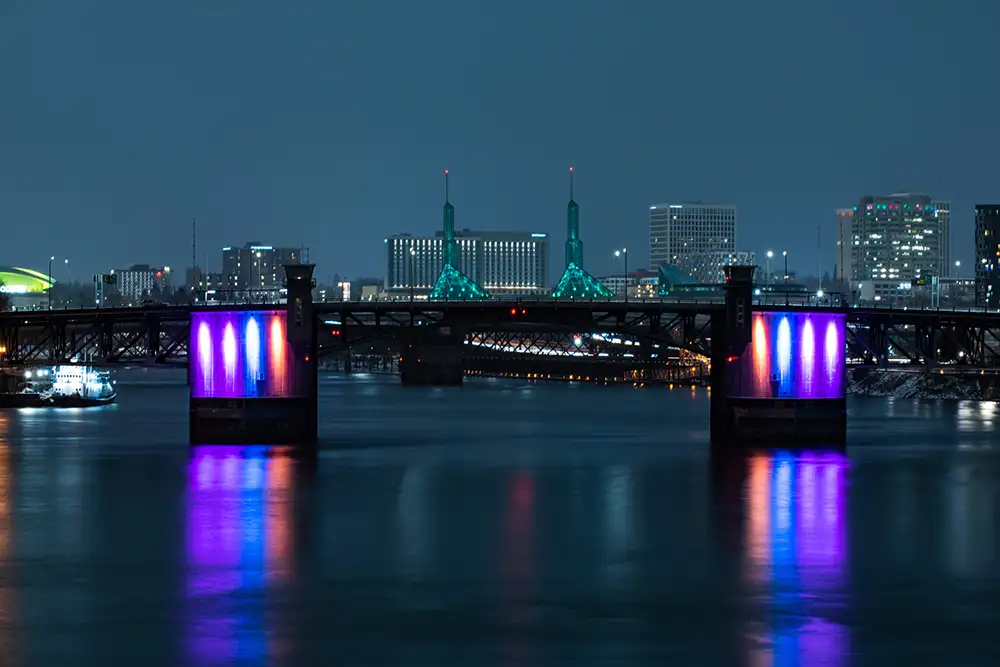 City bridge illuminated at night with purple and pink lights