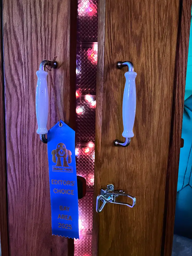 Blue ribbon hangs from light-based art installation