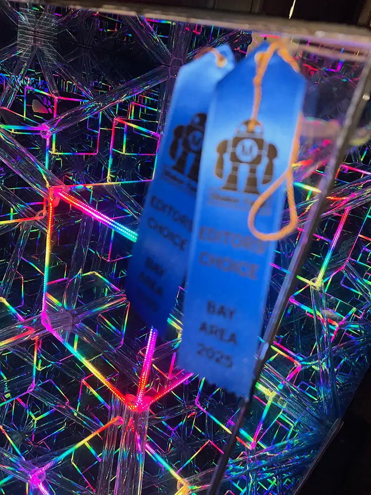 two blue ribbons in front of illuminated art installation