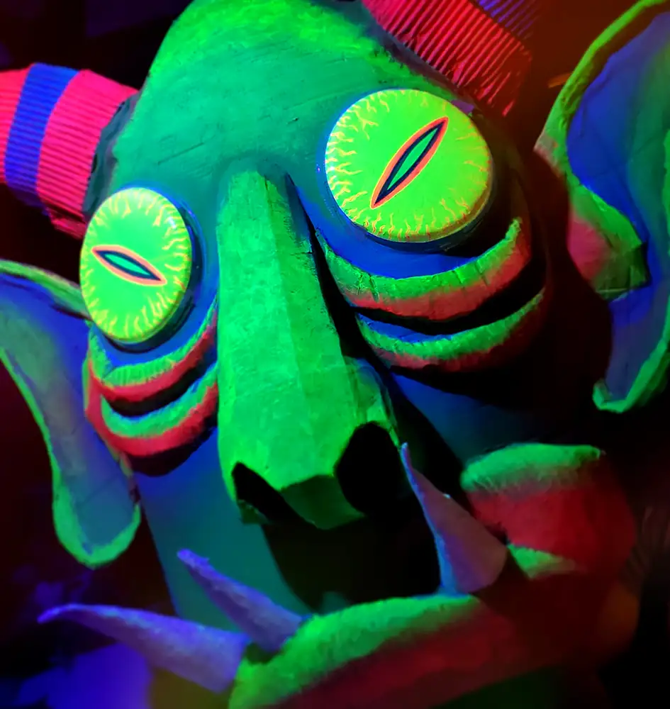 painted cardboard monster puppet head glowing green