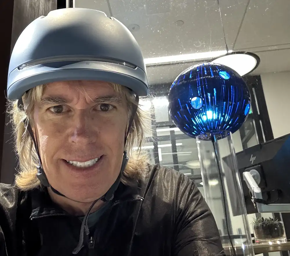 smiling man in bike helmet with globe art